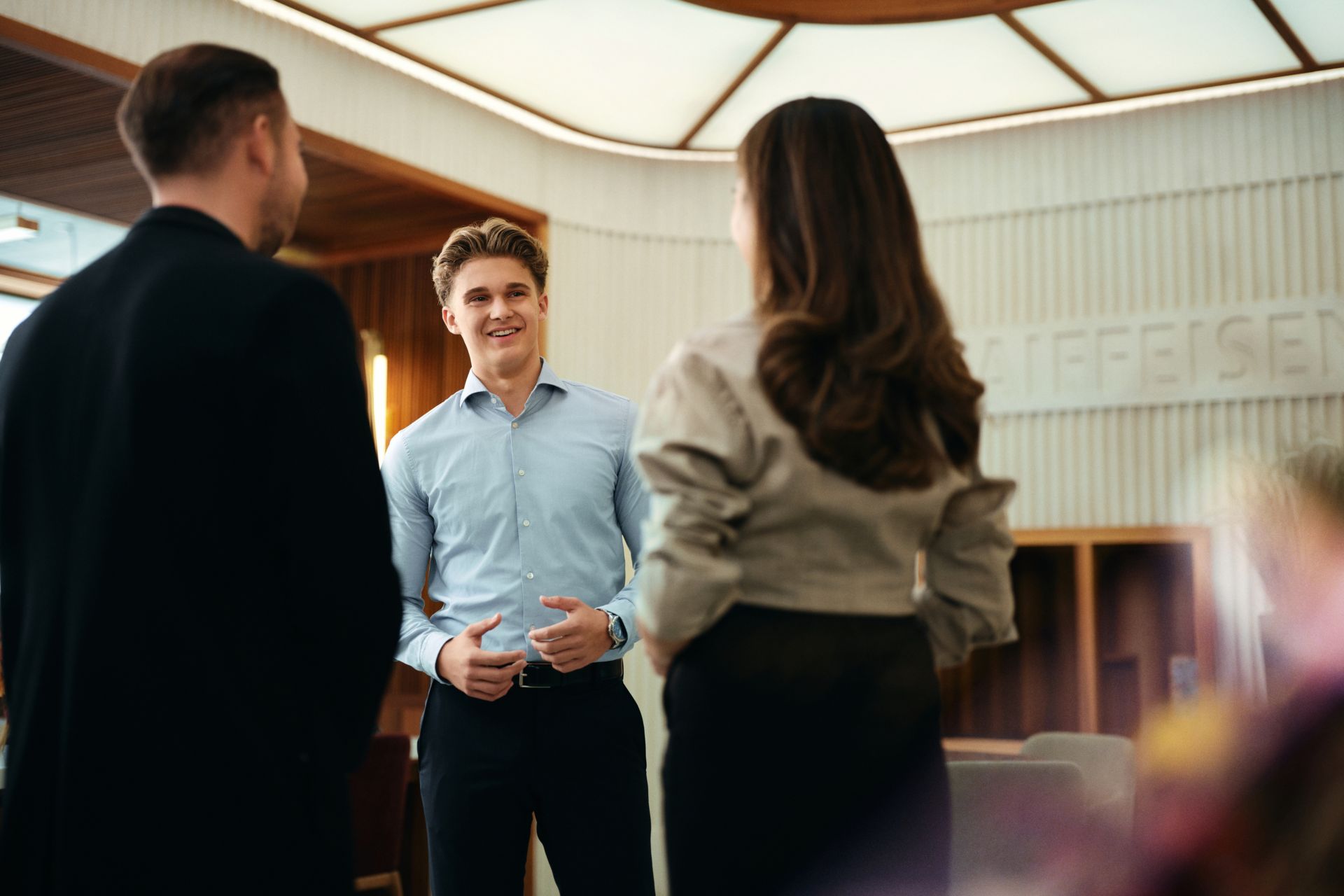 Auszubildender spricht mit Kundin