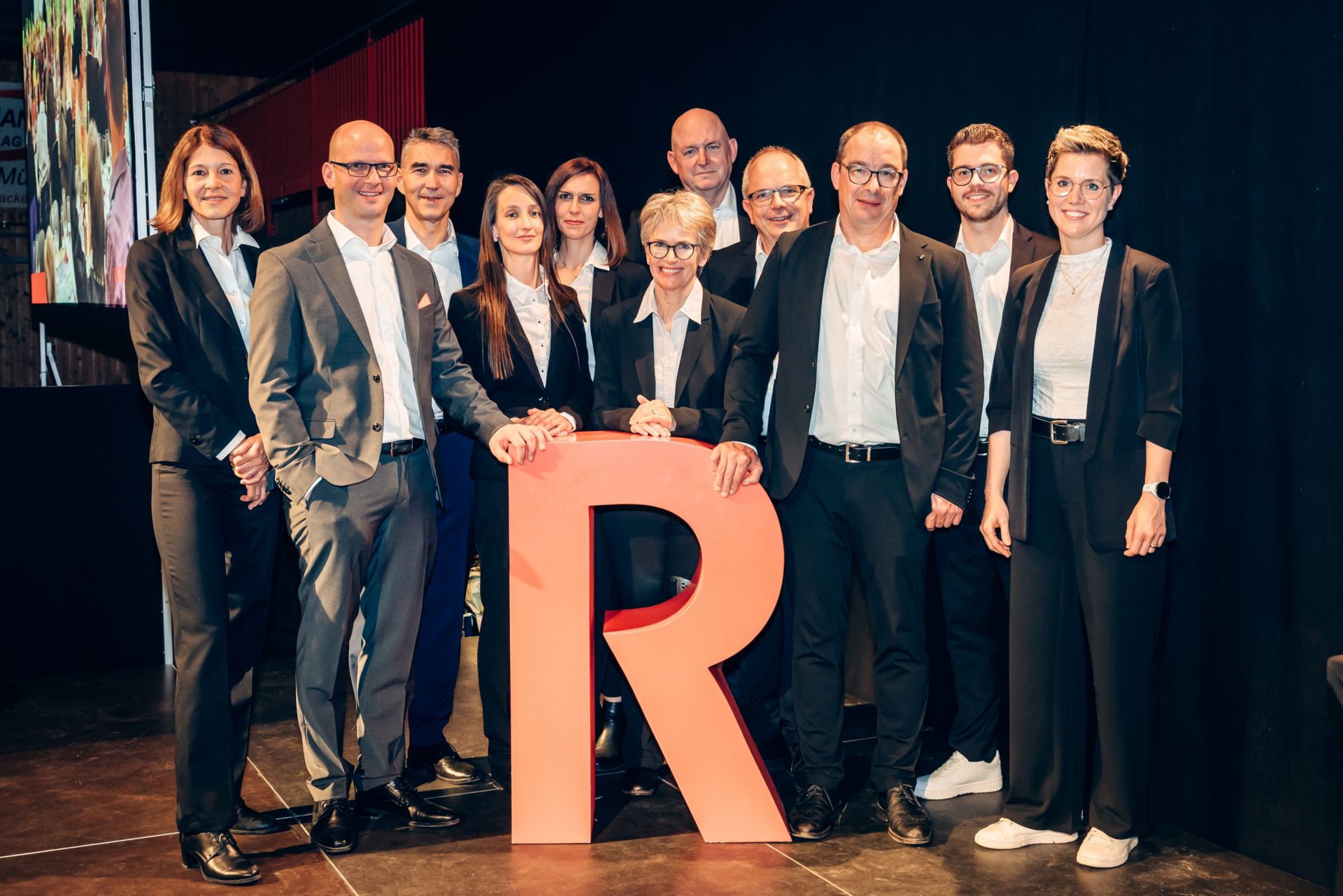 die neuen Bankleitungs- und Verwaltungsratsmitglieder versammeln sich um das Raiffeisen R