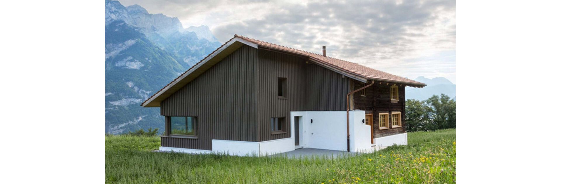 L’expression extérieure et intérieure de la construction en poutres d’origine a été conservée, mais elle a néanmoins été transposée dans le présent. Avec sa façade en bois, l’extension parvient à compléter harmonieusement l’ancien bâtiment, sans pour autant l’écraser.