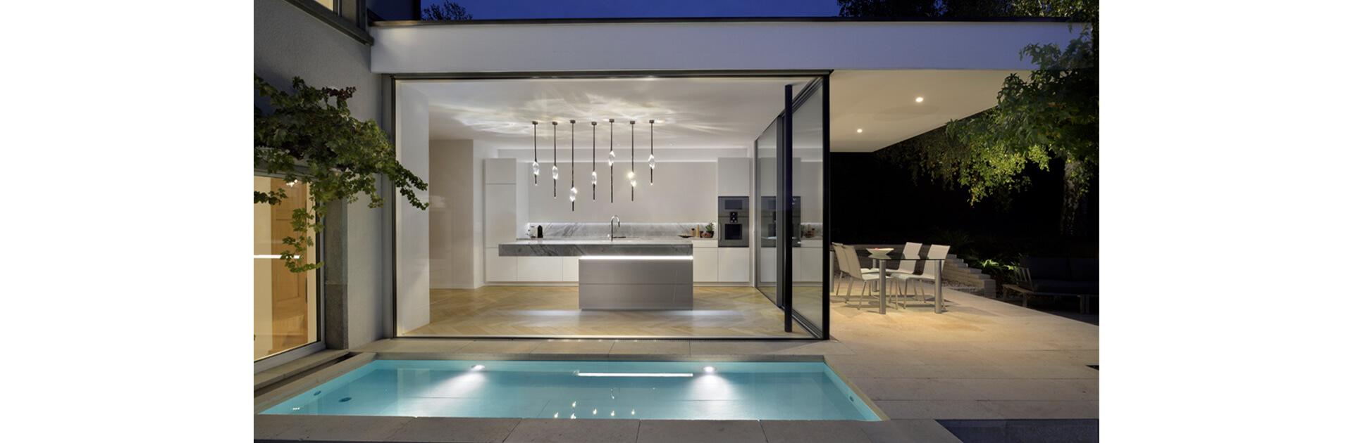 Di notte lo specchio d'acqua di fronte al nuovo edificio annesso fa danzare i riflessi della luce sul soffitto della spaziosa cucina.