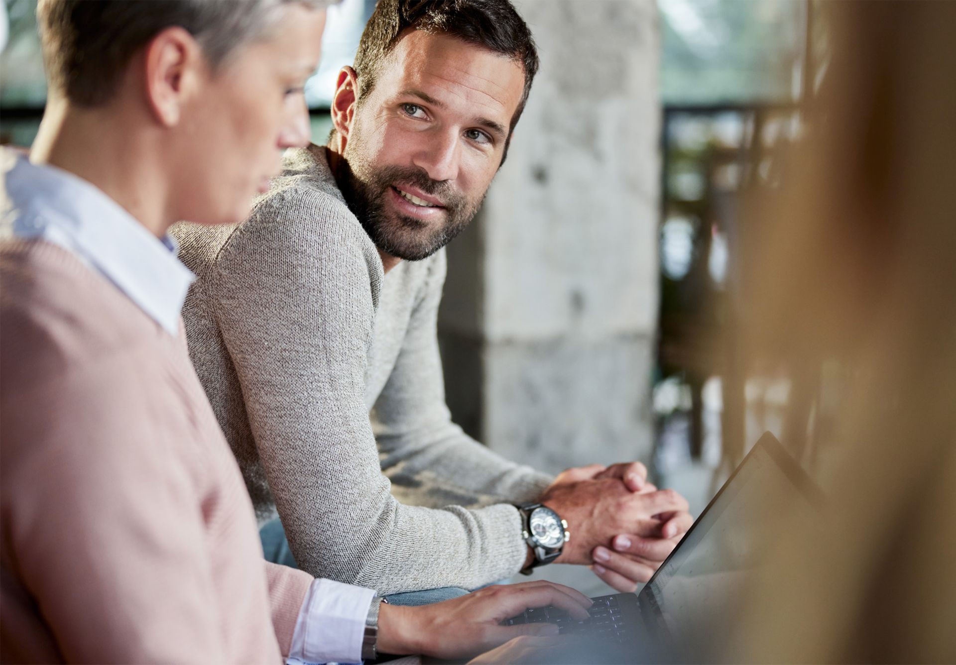 Mann und Frau sitzen vor einem Laptop