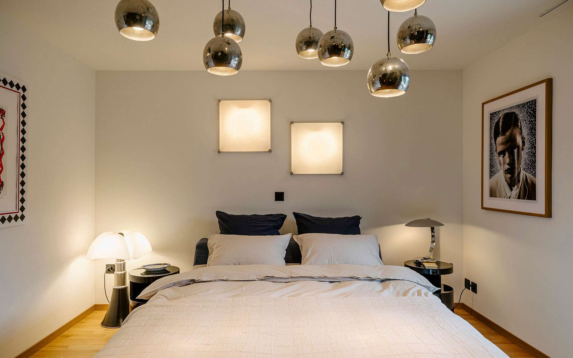 Chambre à coucher avec un mur gris perle et de superbes objets lumineux.