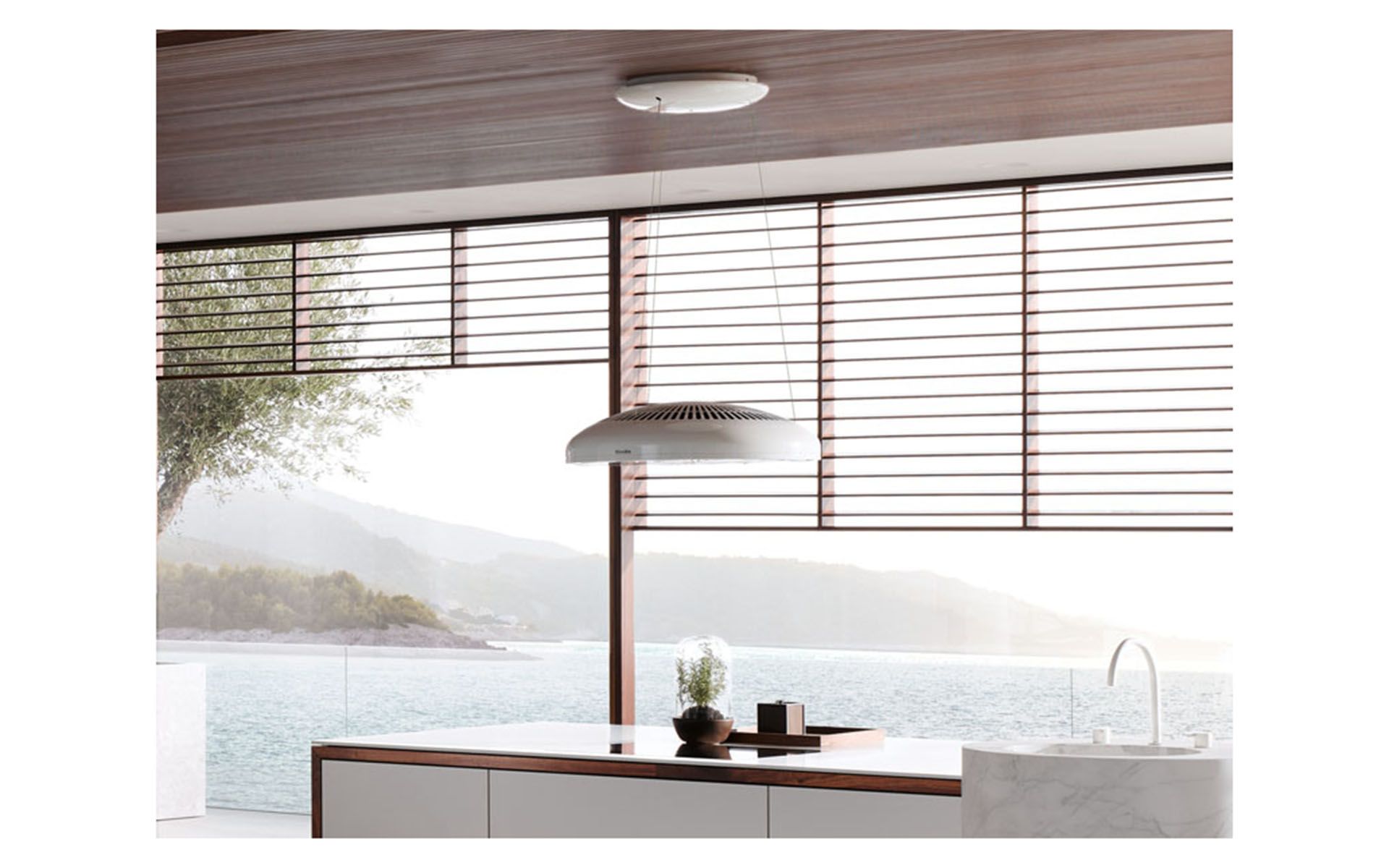 Tutto ciò che è buono viene dall'alto? Questo è probabilmente il caso di «Aura 3.0»: la cappa aspirante a isola, con il suo design innovativo, ricorda più un elegante apparecchio di illuminazione che un apparecchio tecnico. I comandi quasi invisibili e l'alimentazione tramite cavi di sospensione in filigrana completano il design accattivante. La funzione automatica «Con@ctivity» adegua automaticamente anche la potenza della ventola al piano cottura. Foto: Miele