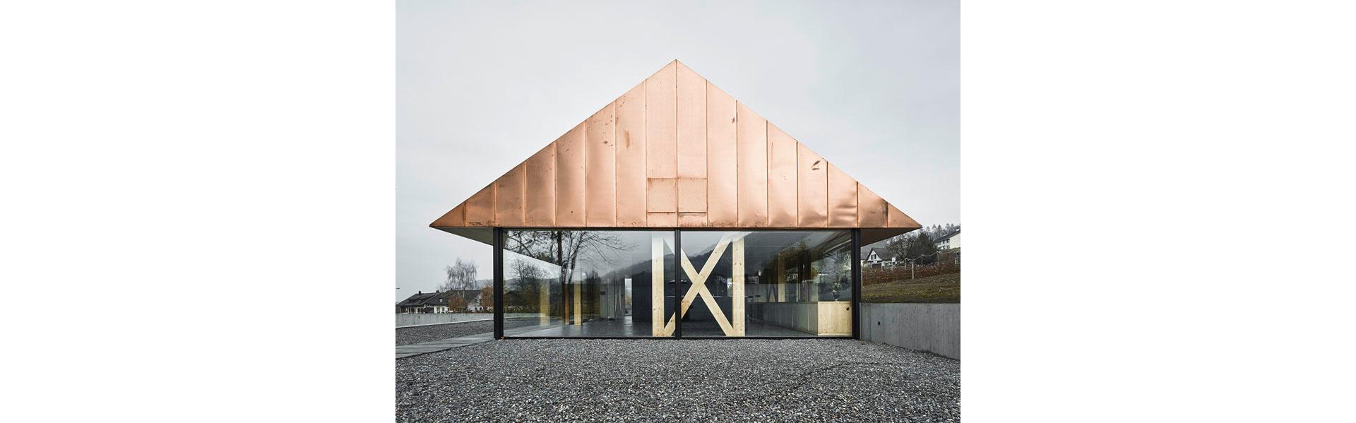 Il tetto in rame è il fiore all'occhiello della casa completamente vetrata. Sul versante del pendio, l'edificio sembra spingere leggermente nel terreno. Questo sfalsamento viene accompagnato all'interno da una credenza per tutta la lunghezza dell'edificio.