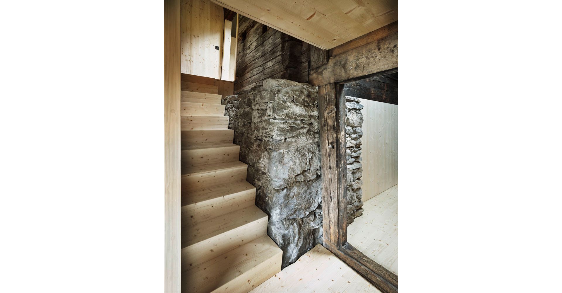 L'ex facciata ovest è stata conservata come parete interna e, grazie alla posizione della scala, è diventata il punto centrale e di collegamento tra il nuovo e il vecchio. I soffitti bassi, la parete tagliafuoco, gli architravi bassi e le traverse erano elementi centrali che sono stati integrati nel progetto e ulteriormente sviluppati.