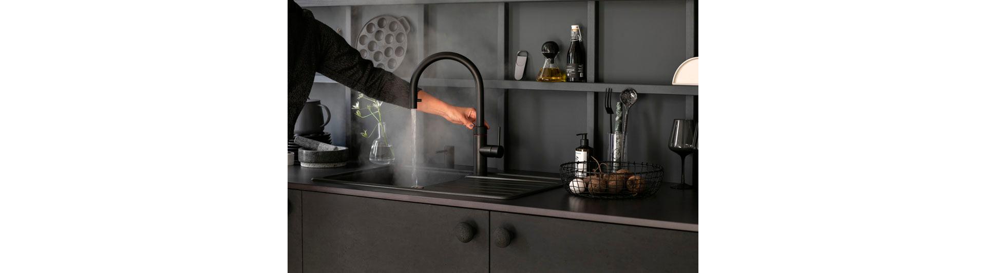 Il «Quooker Flex» nero ha in sé qualcosa di magico e trasforma ogni cucina in un palcoscenico: elegante, misterioso, contemporaneo ed elegante. Dietro al suo aspetto attraente si nasconde un autentico talento, poiché il rubinetto, oltre alla solita acqua fredda liscia, eroga anche acqua bollente, facendo risparmiare tantissimo spazio, tempo ed energia in cucina. In combinazione con il «Cube», questo prodigio di bellezza nero fornisce anche acqua frizzante e filtrata. Foto: Quooker
