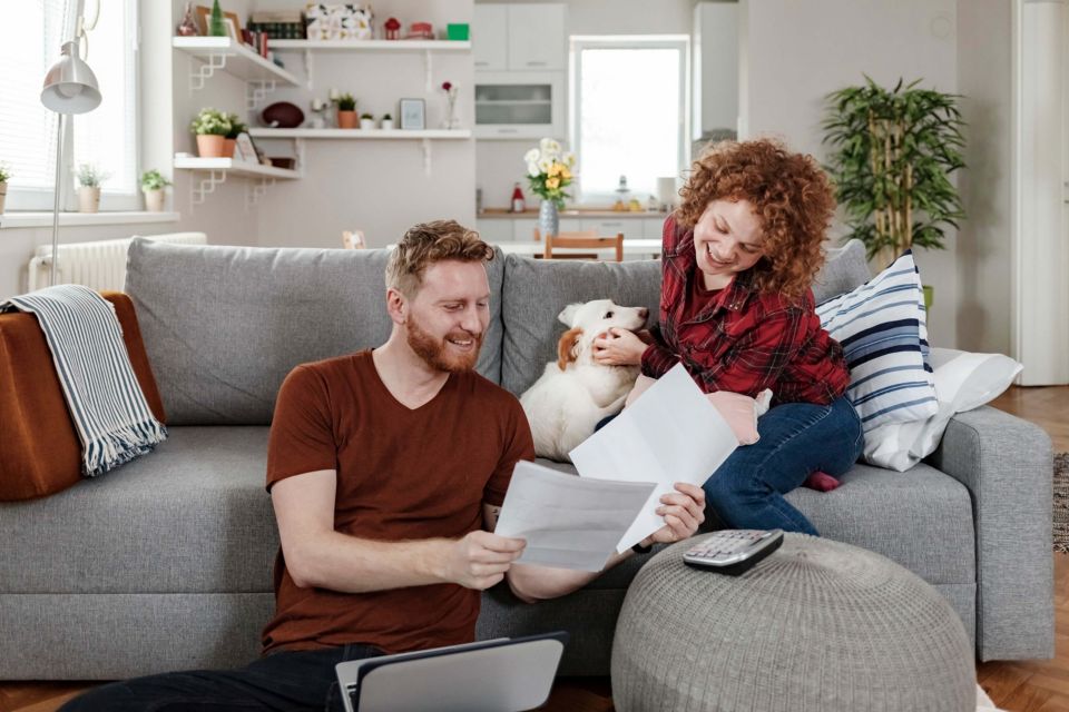 Paar sitzt mit Hund auf dem Sofa