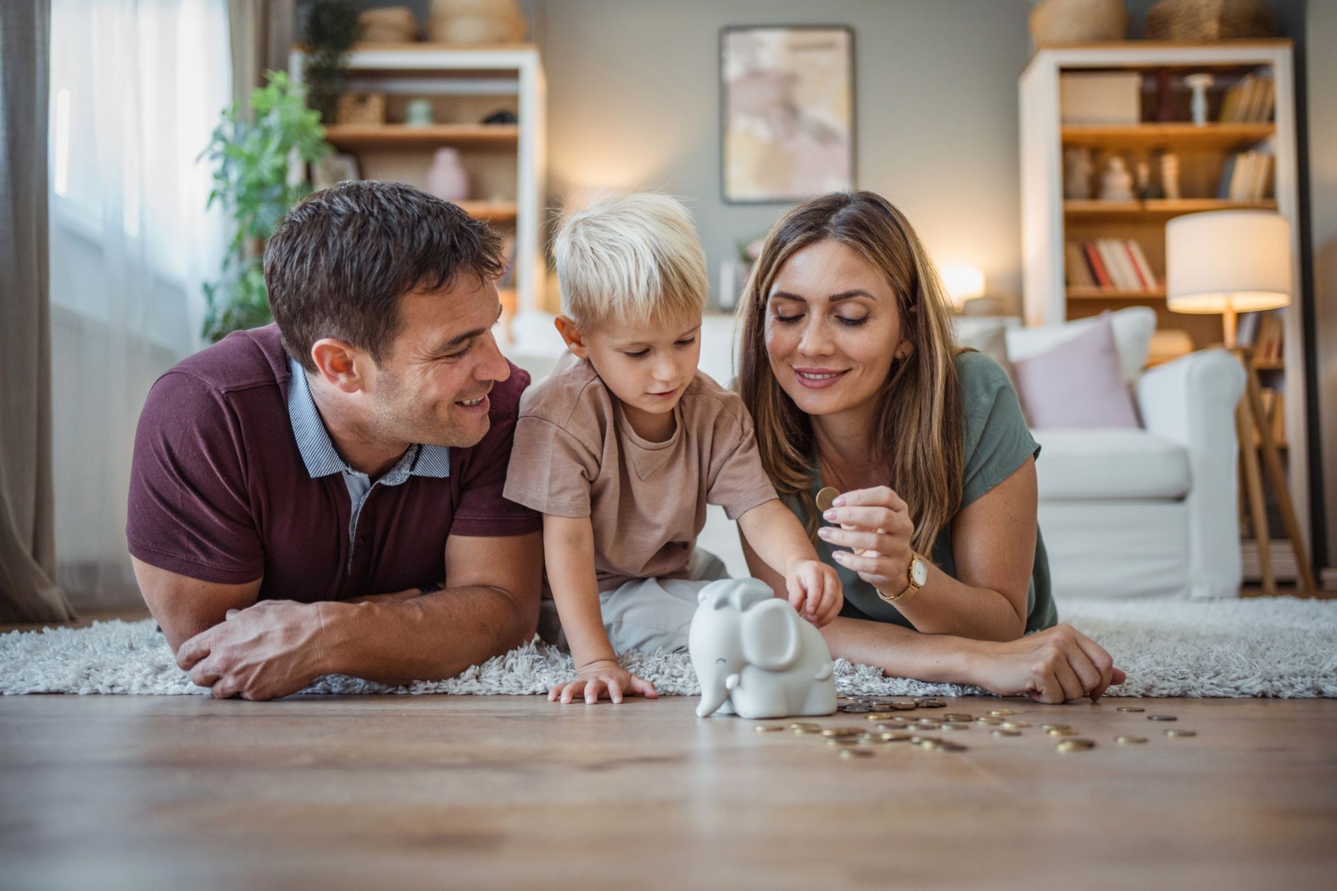 Mann, Kind und Frau füllen ein Sparschwein