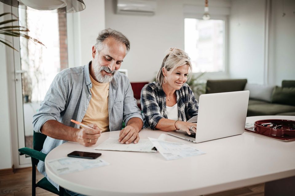 Couple assis à une table et regardant un ordinateur portable
