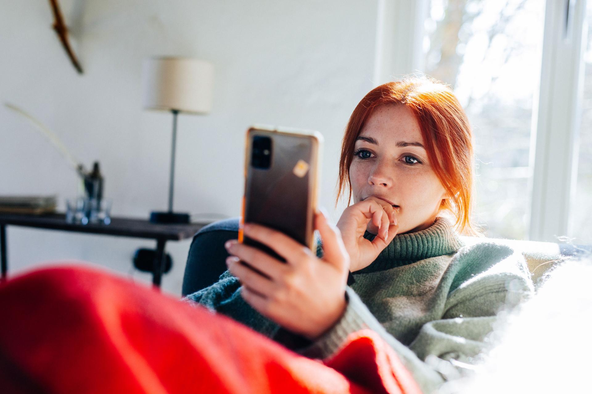 Frau auf Sofa mit Mobile