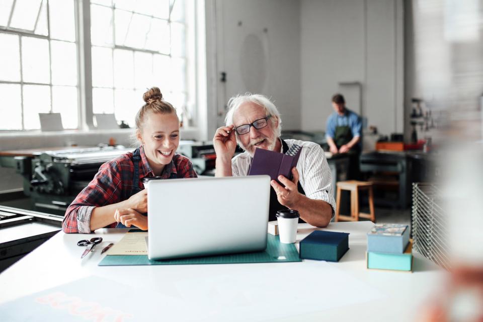 Frau und Mann schauen auf einen Laptop