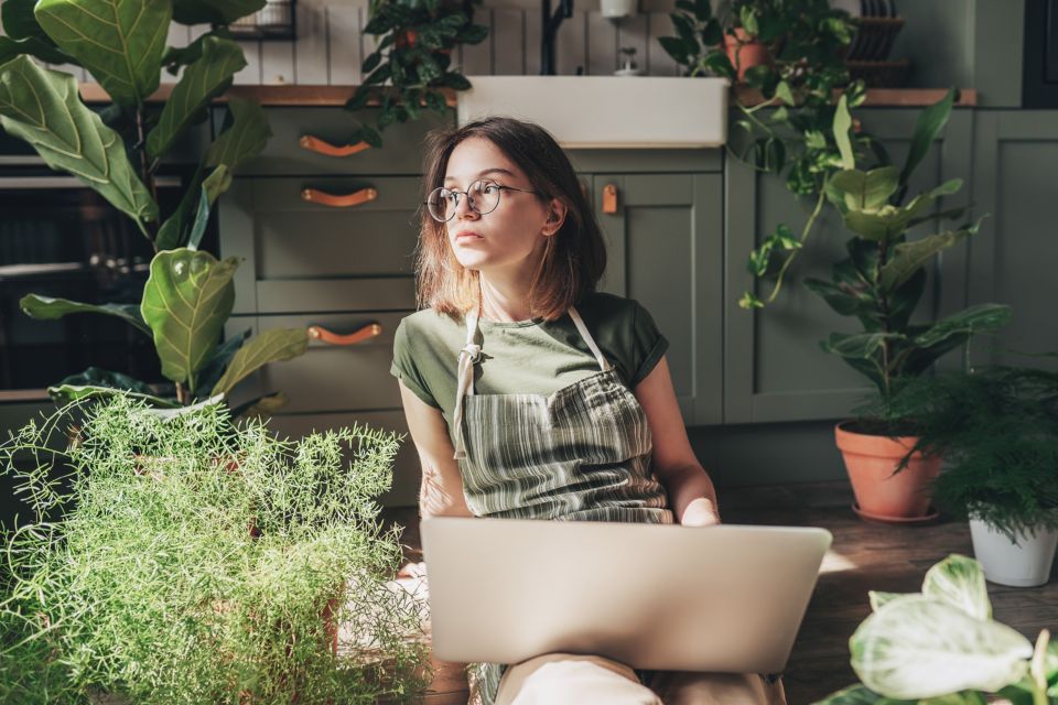 Femme avec son ordinateur portable dans la cuisine