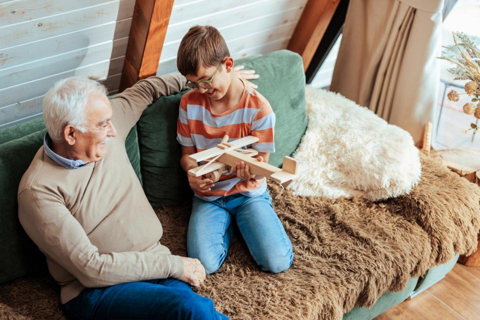 Il nonno fa spiegare al nipote un aeroplano di legno