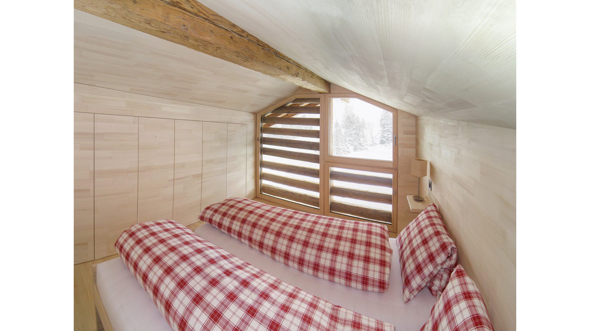 Situé dans un cube aménagé, la chambre à coucher dispose d'une large baie vitrée côté montagne devant laquelle se trouvent des poutres transversales. (Photo: Markus von Bergen)