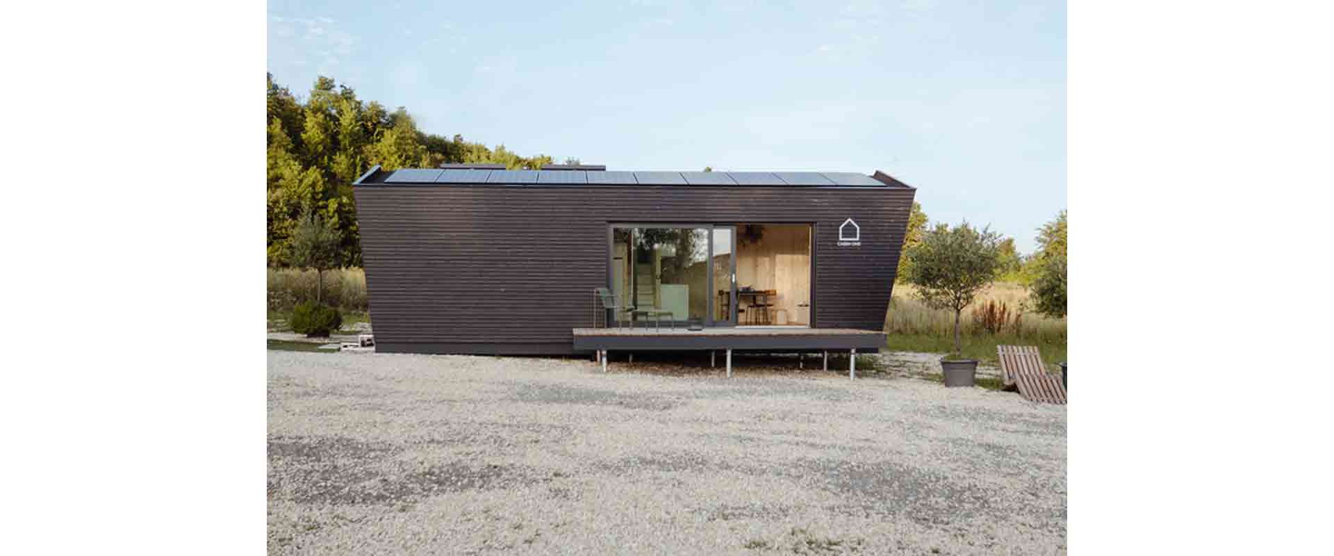 Une forme claire caractérise la construction en bois, y compris une terrasse accueillante et une installation solaire sur le toit.