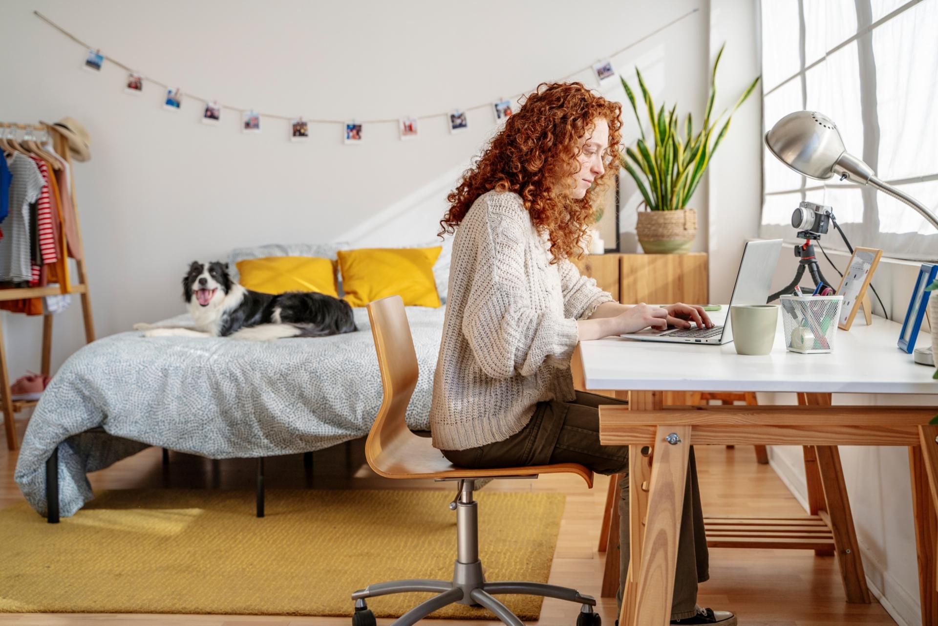 Frau sitzt an Tisch und arbeitet