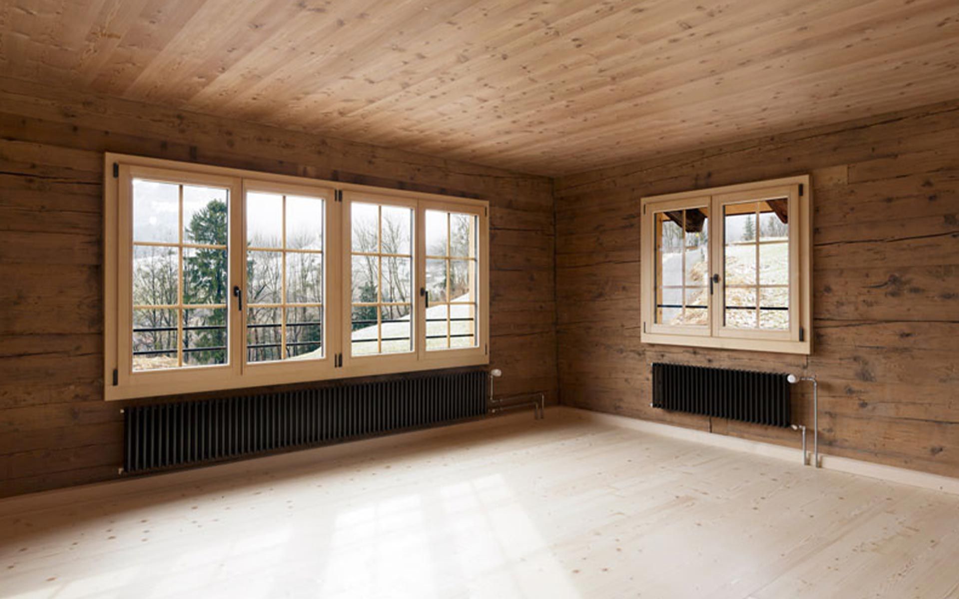 La chambre à coucher à l’étage supérieur profite de fenêtres donnant sur le lac de Walen et les Churfirsten. Les vieux murs en poutres confèrent du charme à la pièce.