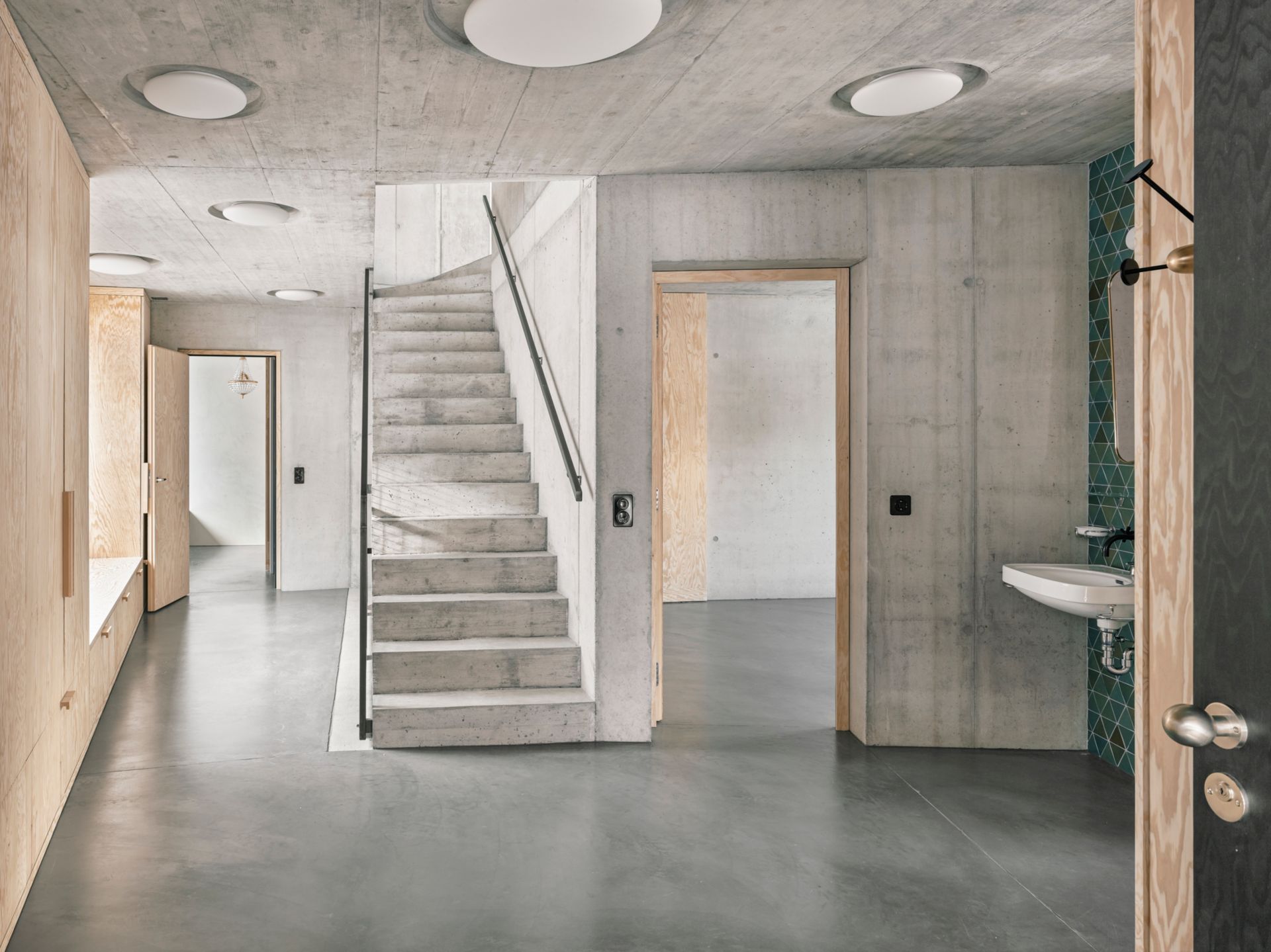 L’entrée est généreusement dimensionnée. Le mur en béton sépare le domaine privatif des espaces communs.