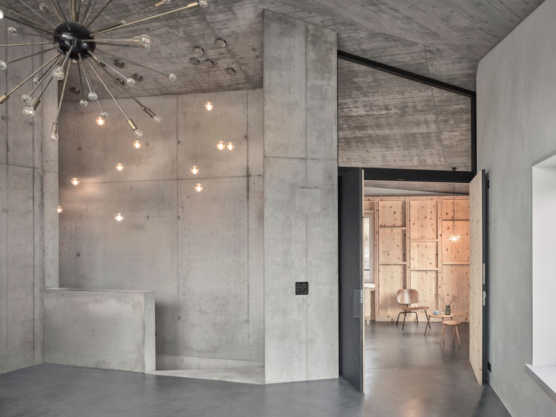 La rugosité du béton confère à l’intérieur un effet sculptural. (Lampes en suspension: Bocci; lampe-étoile: Sputnik)