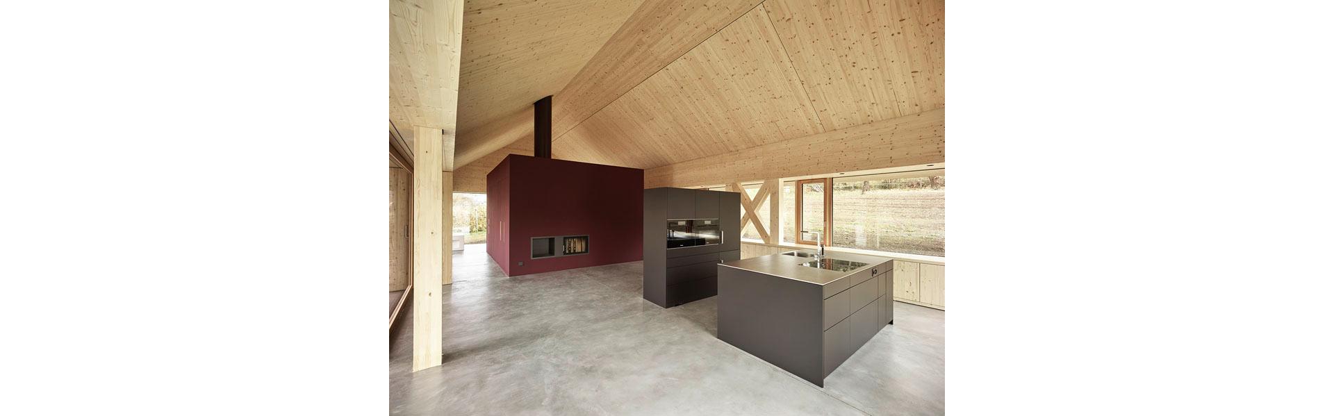 A l’intérieur, le toit apparaît à l’état naturel. Un noyau central, qui abrite les pièces annexes, délimite la zone de la maison d’habitation. Les portes coulissantes permettent de séparer visuellement l’espace intérieur.