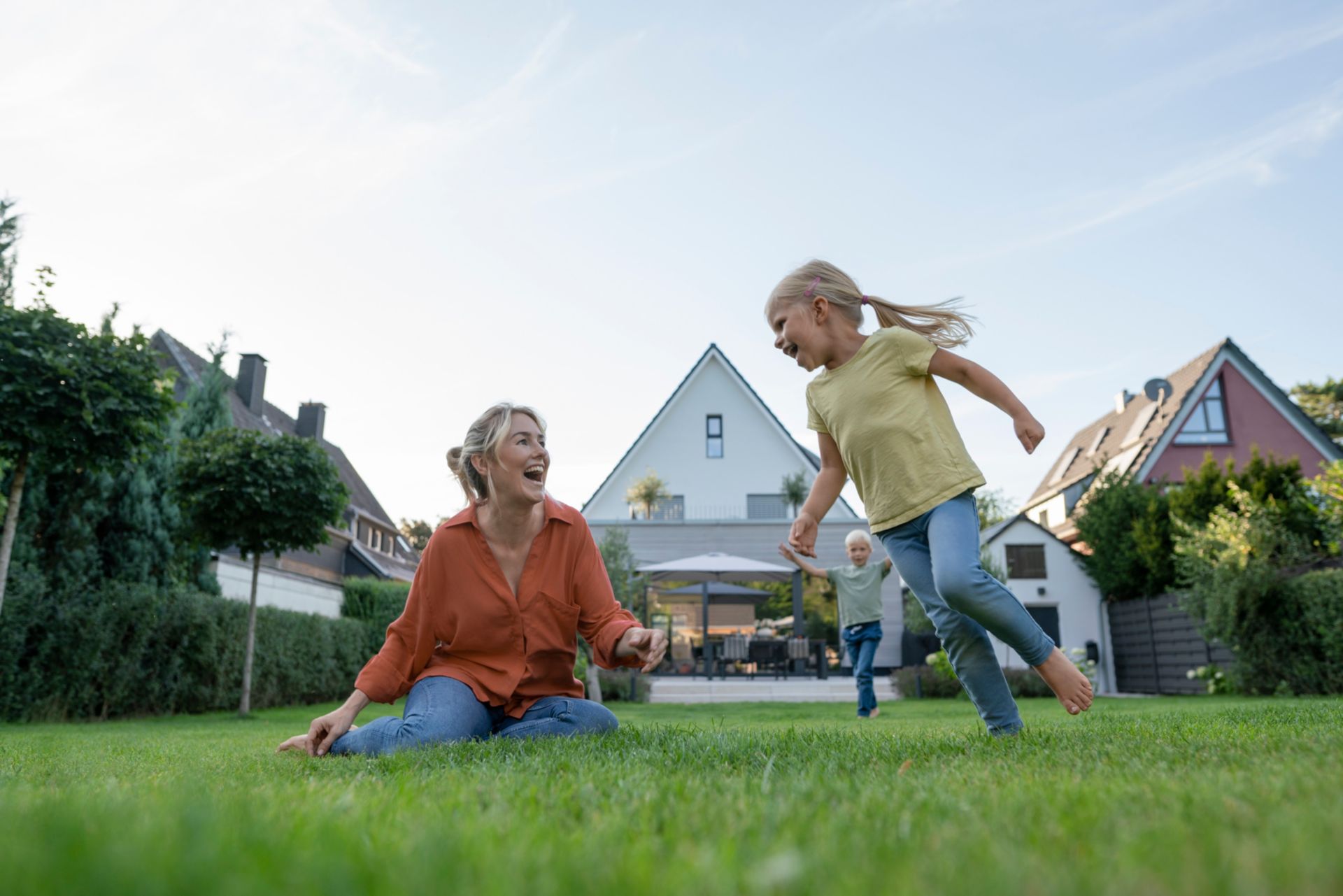 Mutter und Kinder spielen im Garten