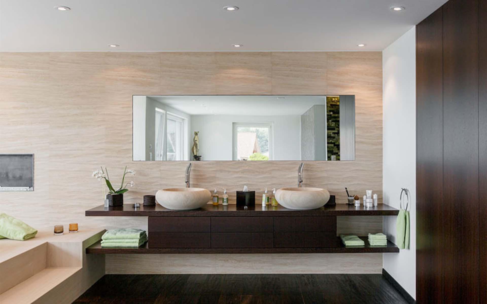 Le vasche in pietra naturale di Ocra Sabbia sono state modellate a mano e vengono sostenute da una sottostruttura dalle linee chiare. Foto: Stone Group